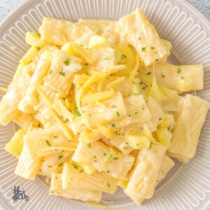 Overhead view of a white plate filled with rigatoni pasta covered in a Gorgonzola Sauce with Apples