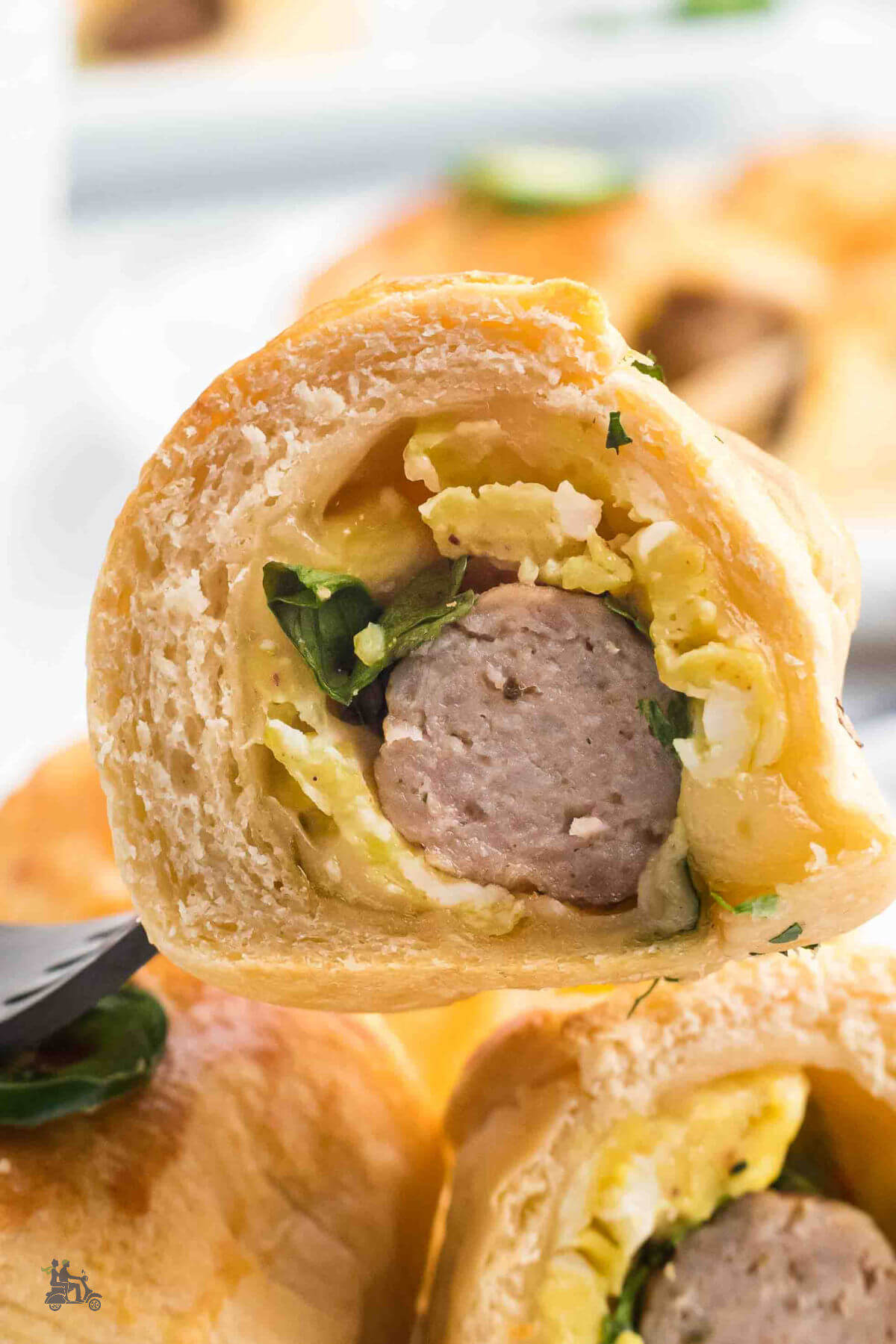 Closeup of the breakfast crescent roll with the sausage rolled in it with cheese and egg. 