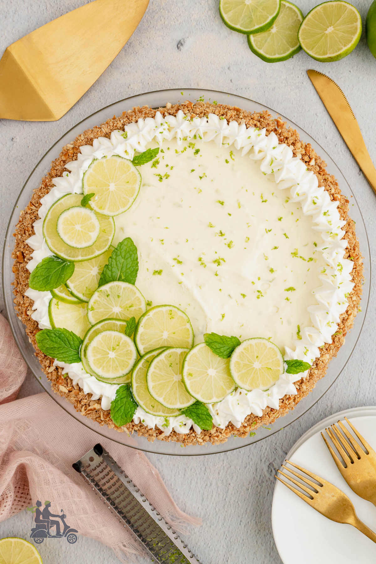Key lime pie finished with lime slices and a ring of whipped cream. 