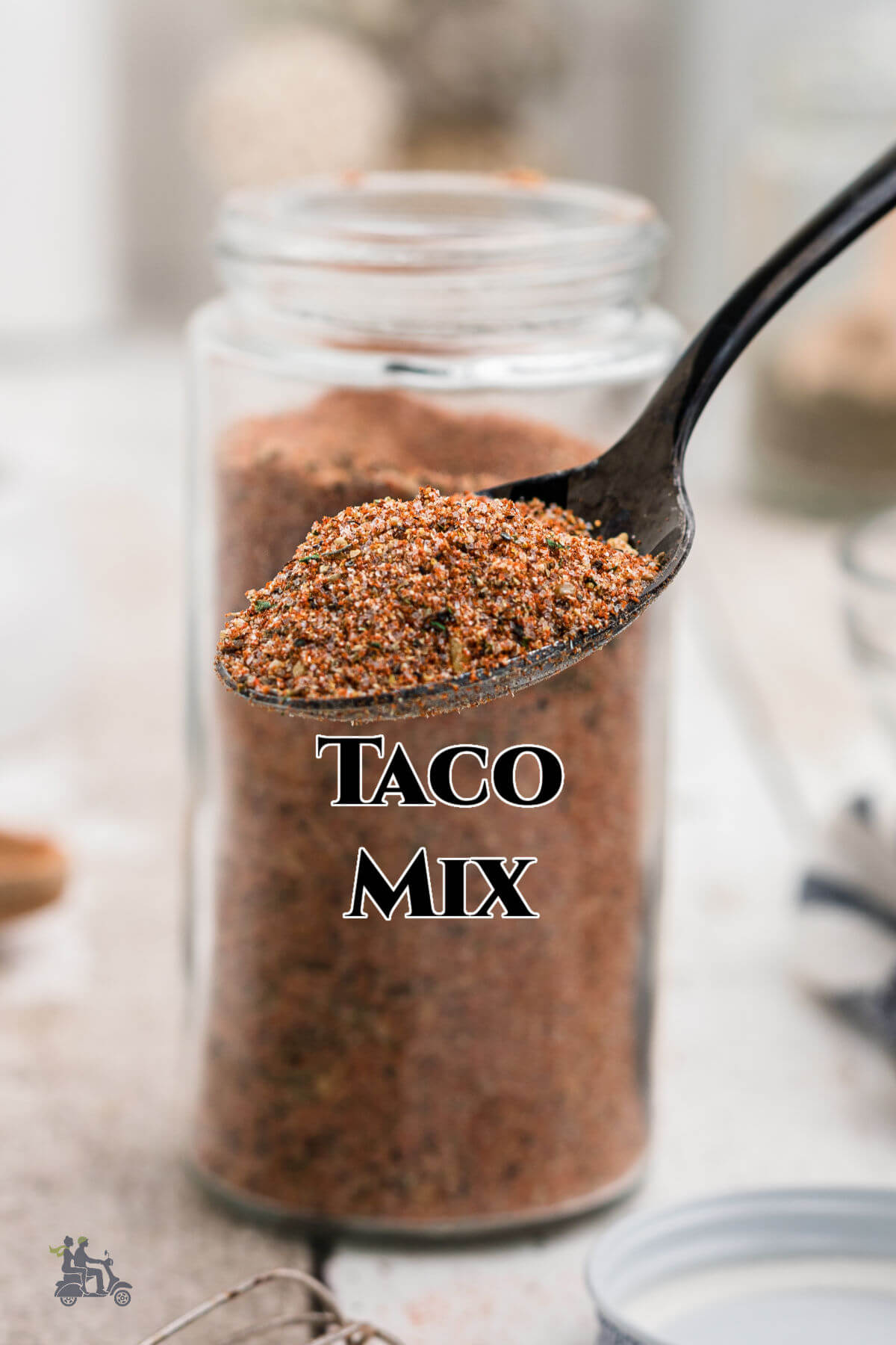 Glass jar filled with Homemade Taco Seasoning plus spoon with a sampling. 