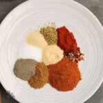 A white plate with the individual ingredients for the taco mix recipe.