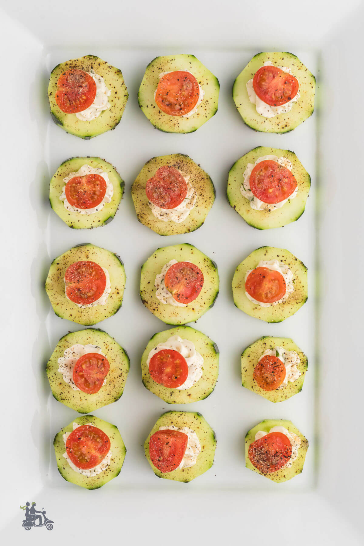 A white tray filled with cucumber appetizer bites. 