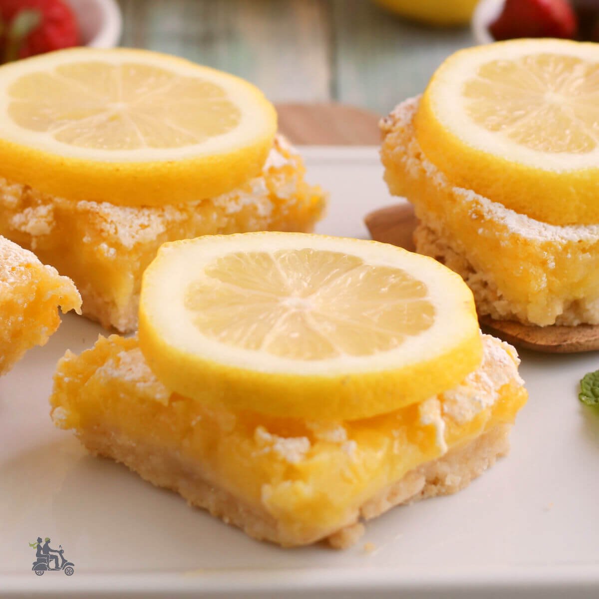 Lemon Squares sprinkled with confectioners sugar and topped with lemon slice.