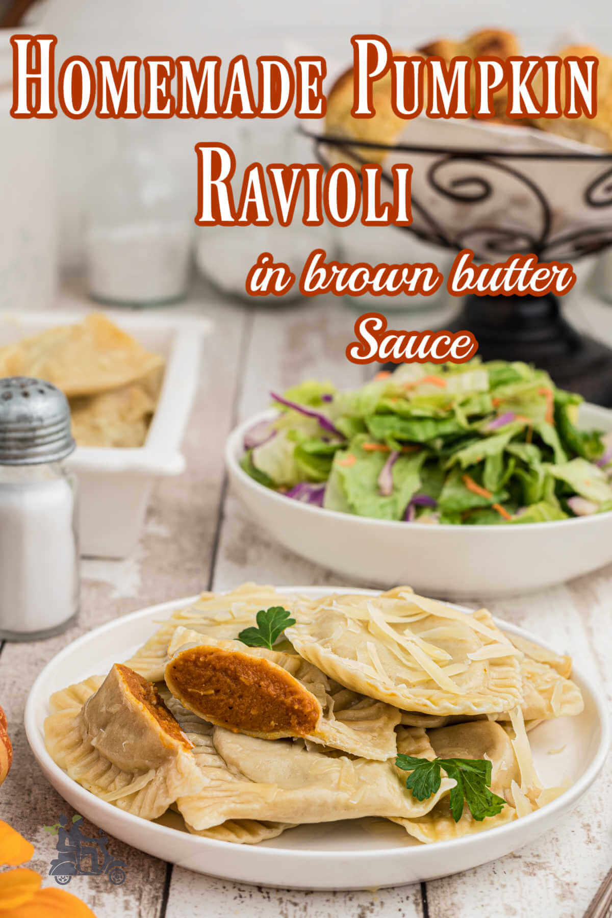 Pumpkin filled ravioli on a white plate with a salad and dinner rolls on wooden table. 