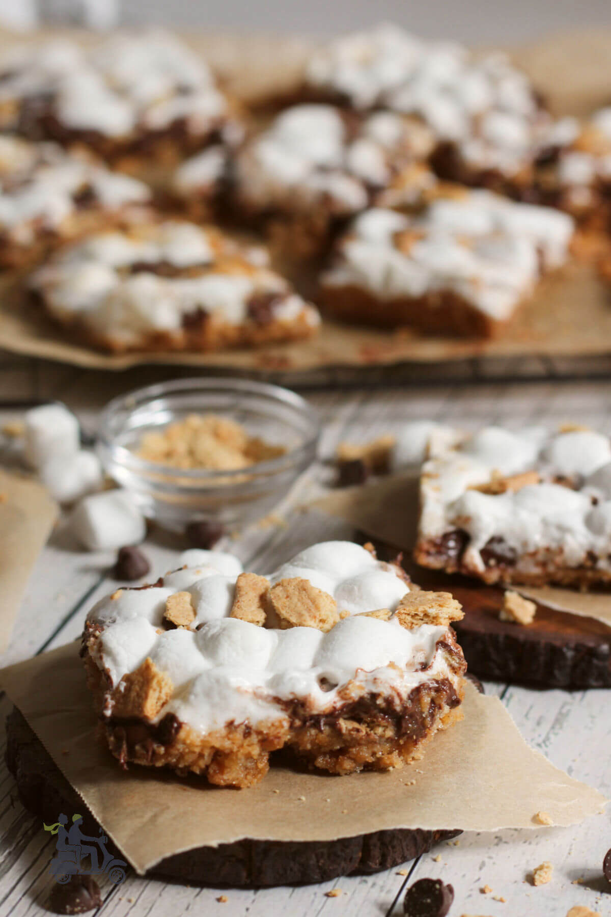 S'Mores bars on squares of brown parchment paper. 