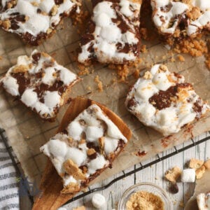 Smore bars on parchment paper with wooden spatula.