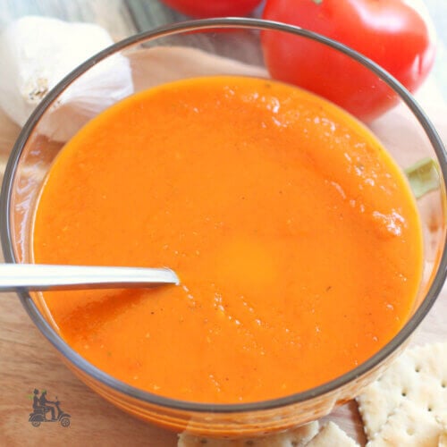 A bowl of tomato bisque with spoon.