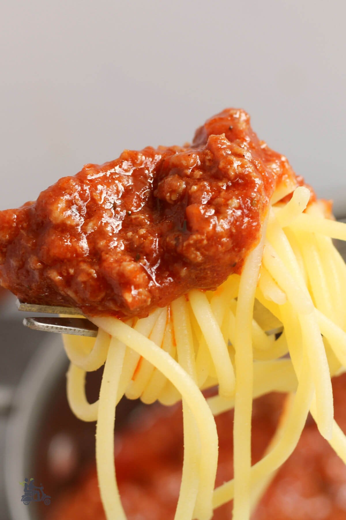 A forkful of spaghetti covered in Italian meat sauce. 