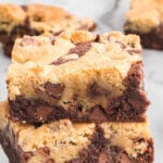 Pinterest Image and Title overlay of the Brookies Recipe with a stack of cookie bars and more individual on a white marble counter.