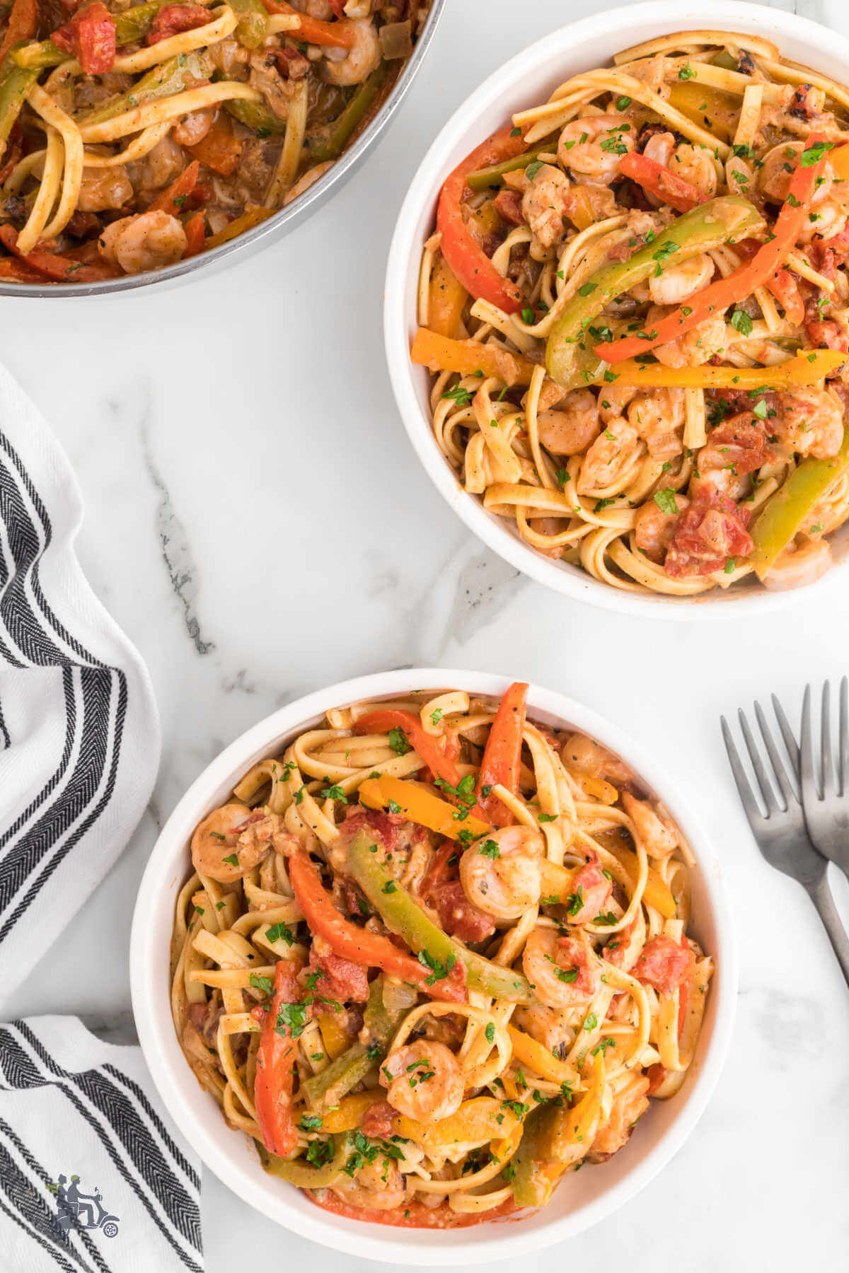 Two bowls filled with colored peppers and shrimp to make the recipe Rasta Pasta. 