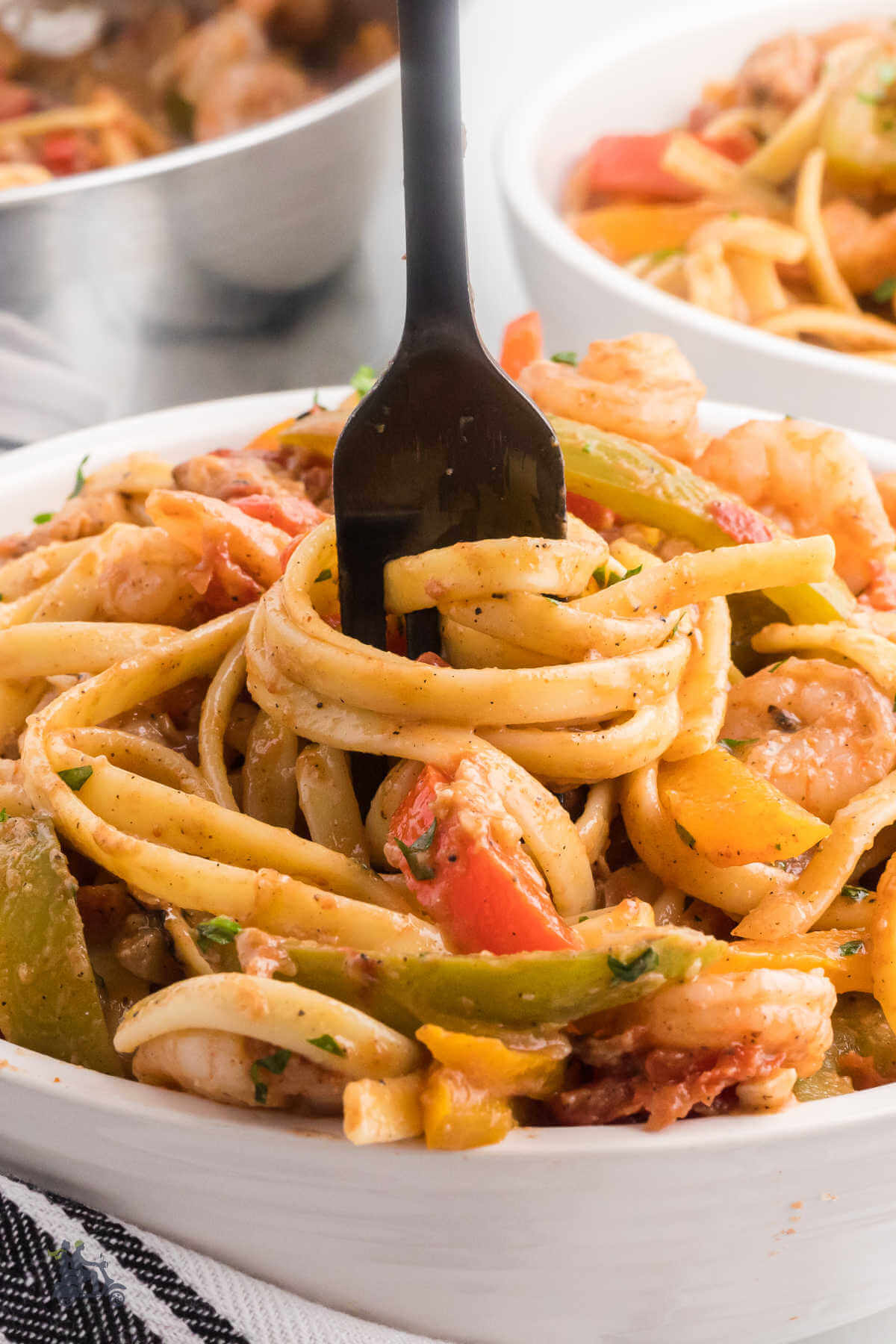 A bowlful of shrimp rasta pasta with a fork in the dish. 