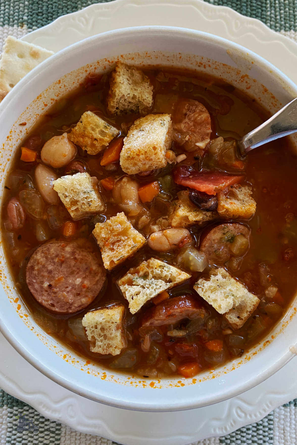 A large bowl of 15 bean soup with homemade croutons on top. 