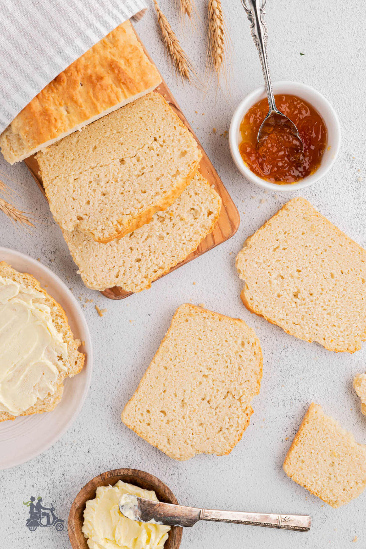 Overhead view of the sandwich bread sliced with slices on the counter and one slice buttered. 