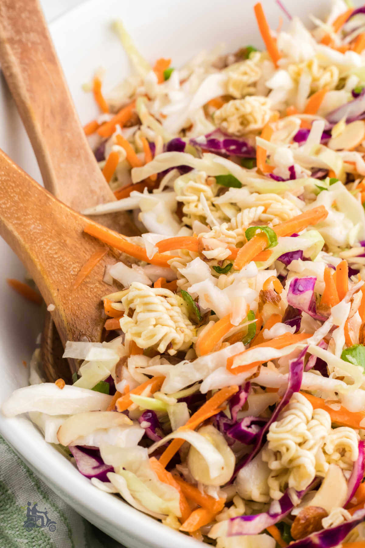 Wooden Salad Serving Spoon and Fork in a large white bowl of Asian Ramen Noodle Salad recipe. 