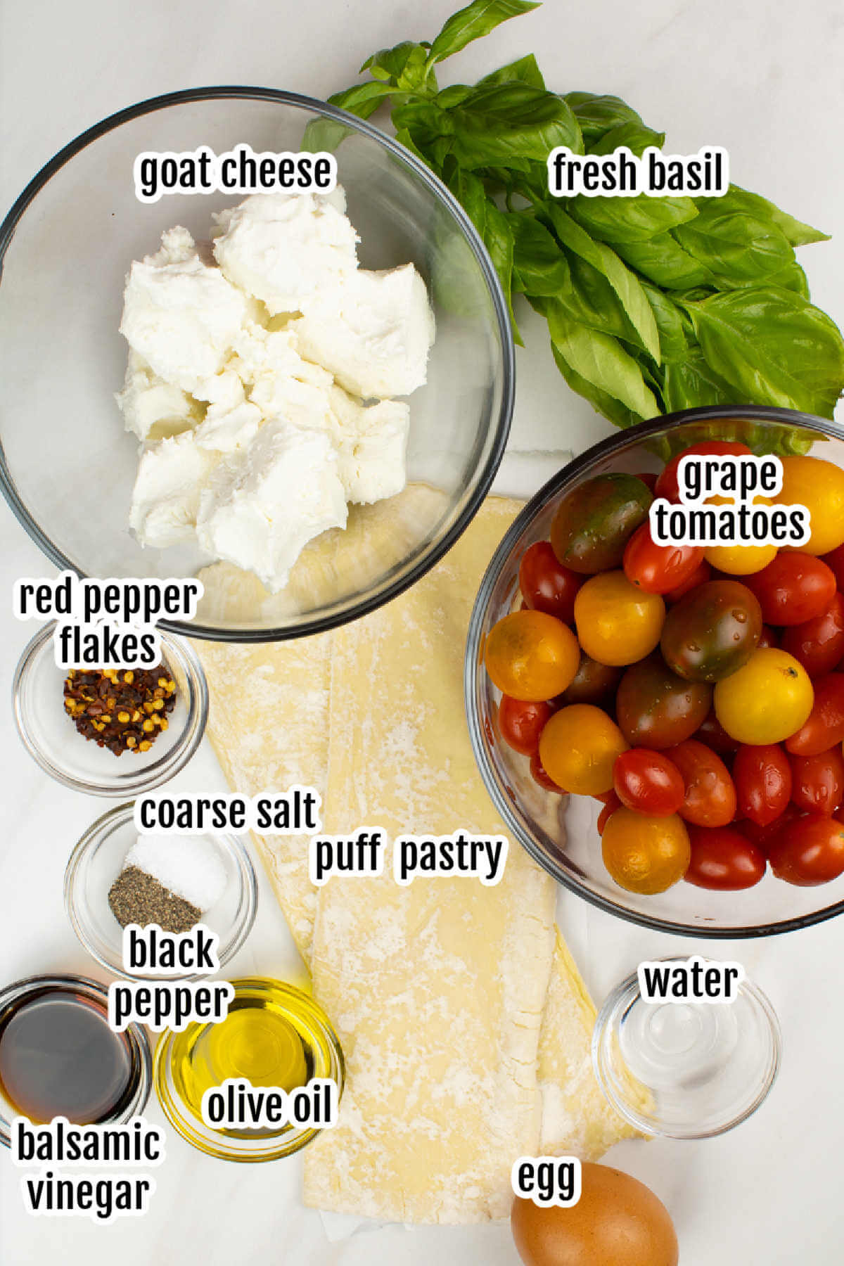 Ingredients needed to make a puff pastry pizza with grape tomatoes and goat cheese. 