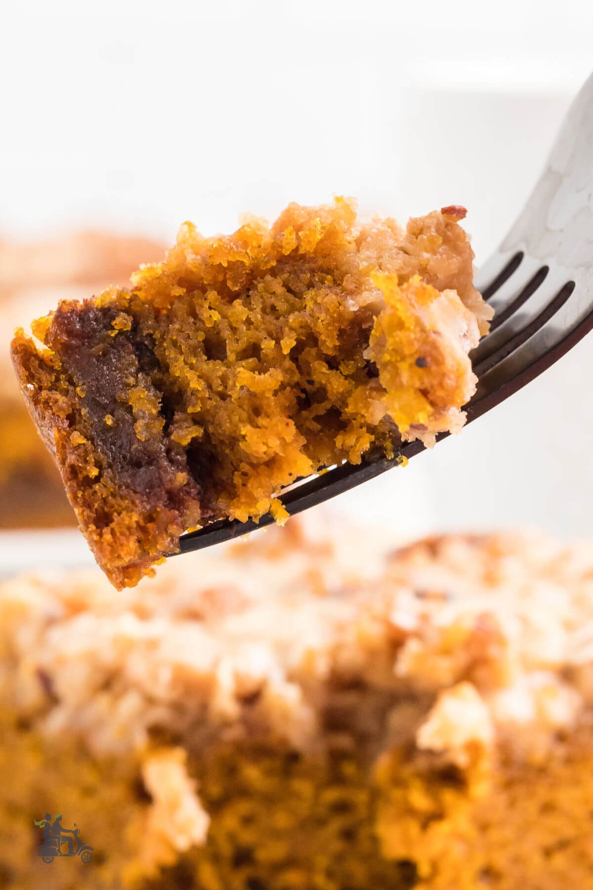 A fork holding a piece of maple glazed streusel pumpkin coffee cake. 