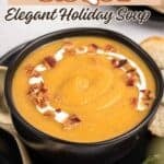 Roasted butternut squash cooked into a smooth creamy south and served in a brown crock bowl. The bisque is topped with creme fraiche and bacon bits.