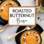 An overhead view of two bowls filled with creamy butternut squash soup and topped with creme fraiche and bacon bits.