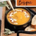An elegant holiday soup made with butternut squash and served in a dark brown crockery bowl.