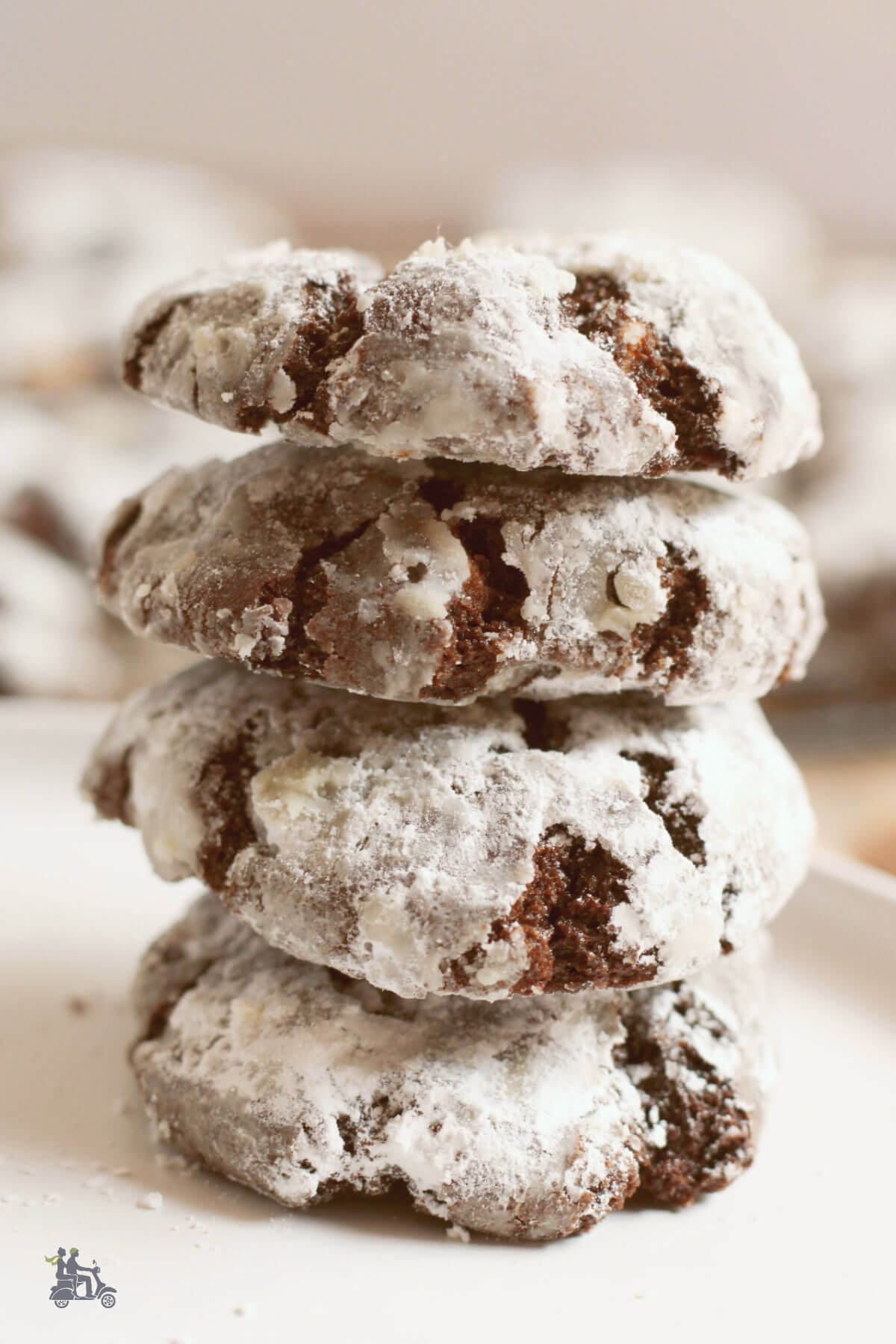 A stack of chocolate crinkle cookies covered in powdered sugar. 