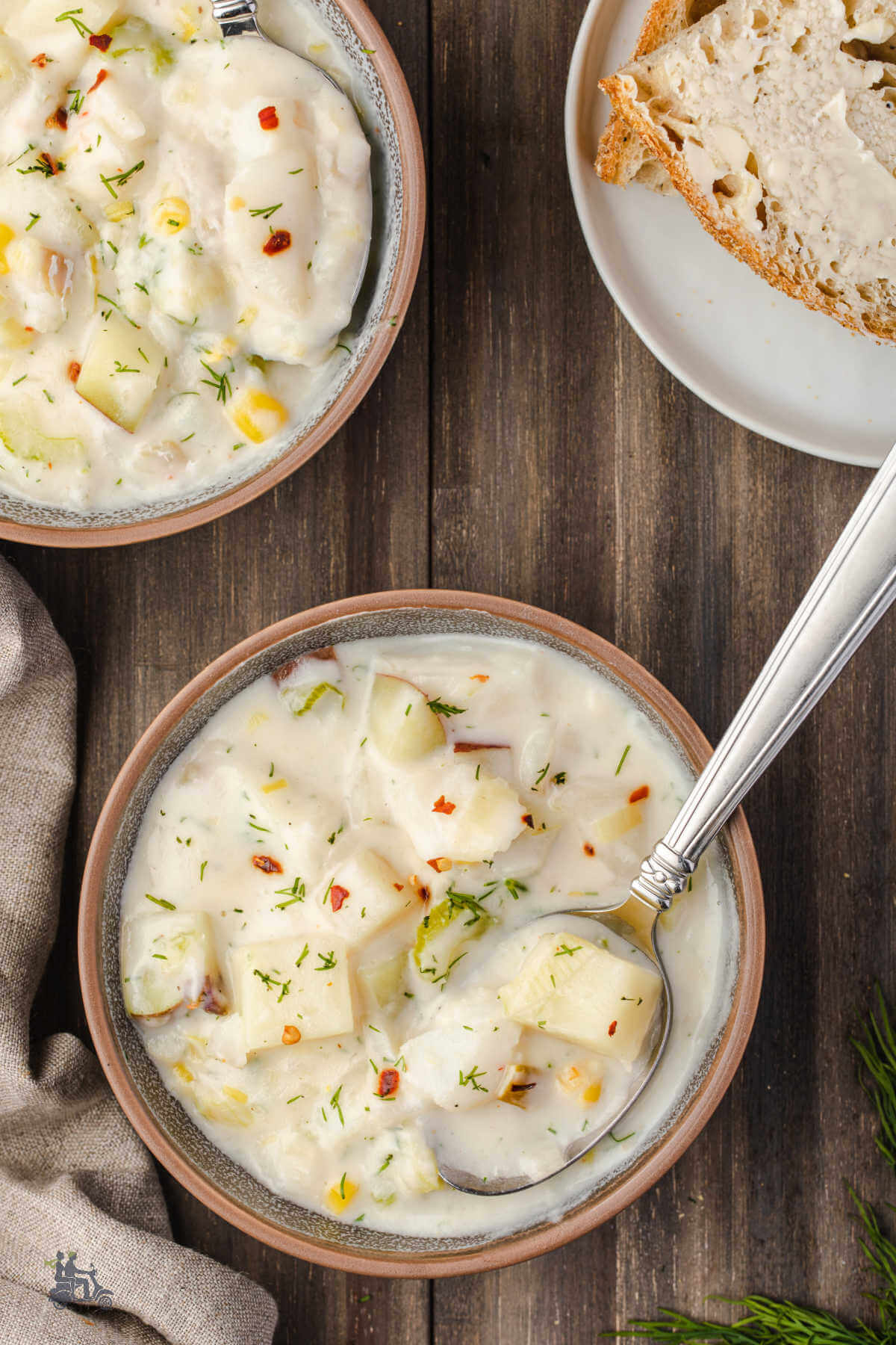 Two brown bowls filled with thick fish chowder made with sheepshead fillets, potatoes, and corn. 