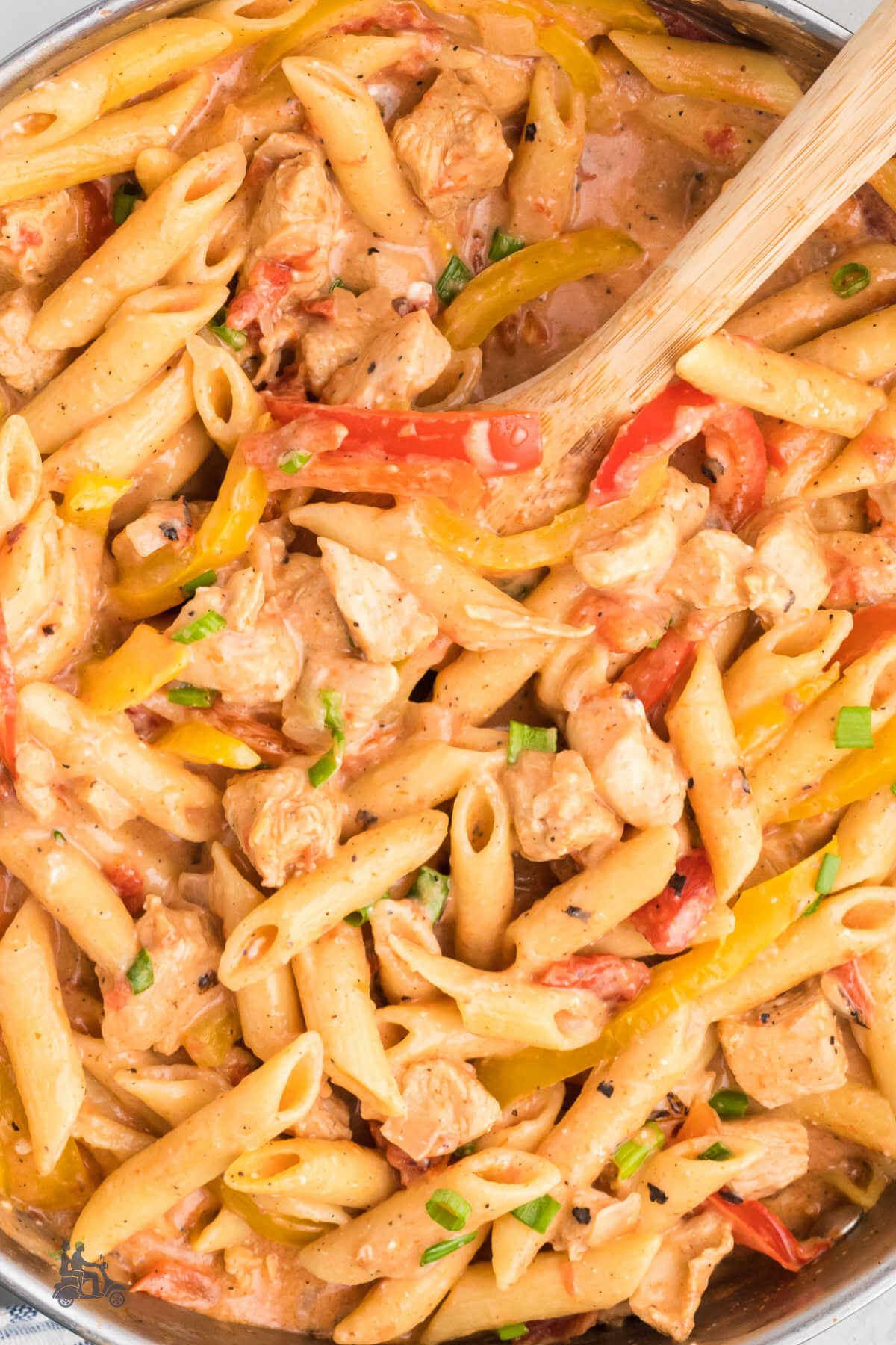 A close up of the penne pasta bathed in a creamy cajun sauce along with chicken bites and bell pepper slivers. 
