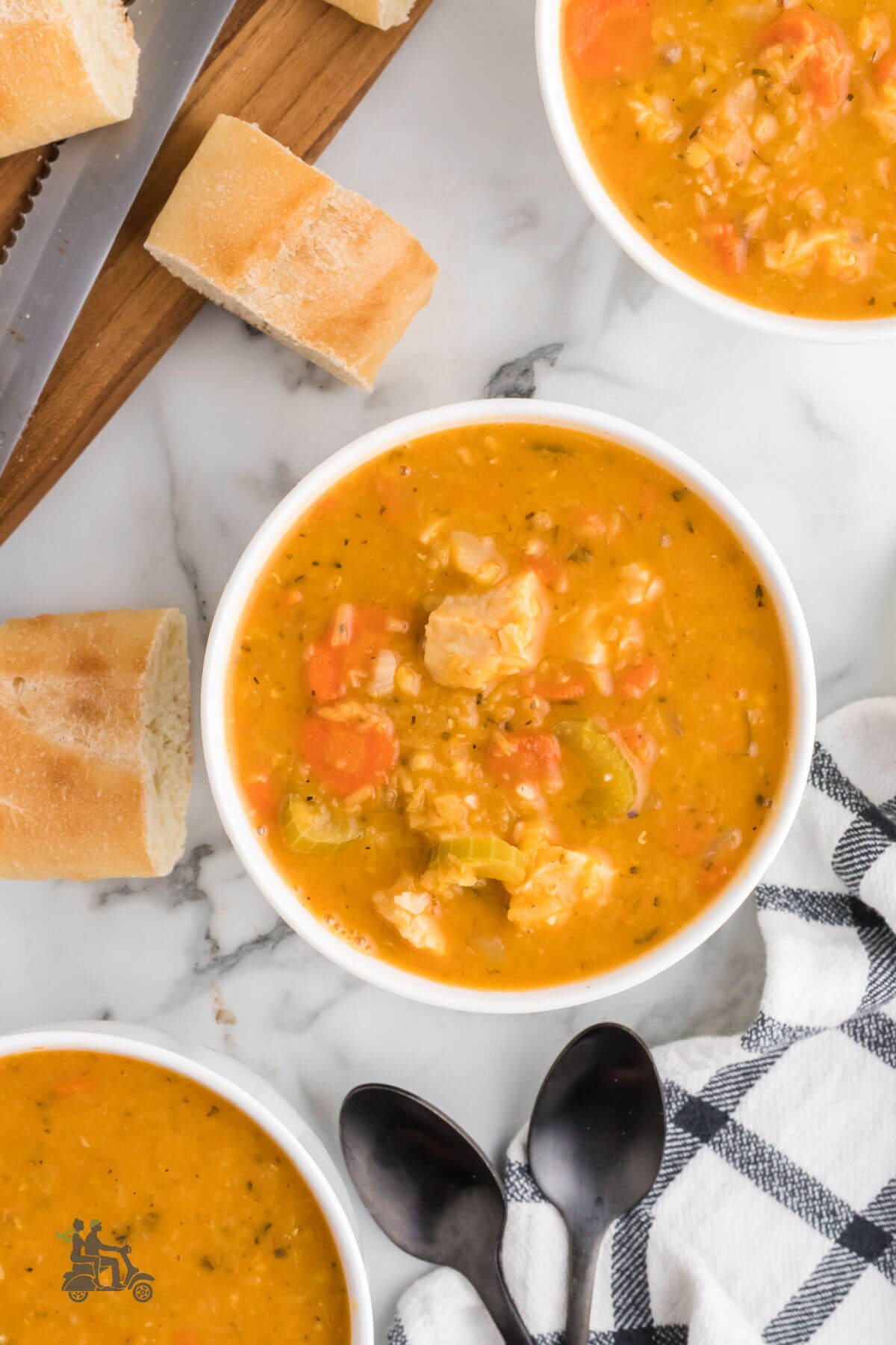 Lentil Soup make with rotisseries chicken in three bowls on the counter with baguette slices on the side. 