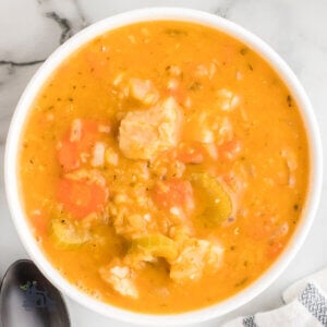 A white bowl filled with chicken lentil soup a Mediterranean dish.