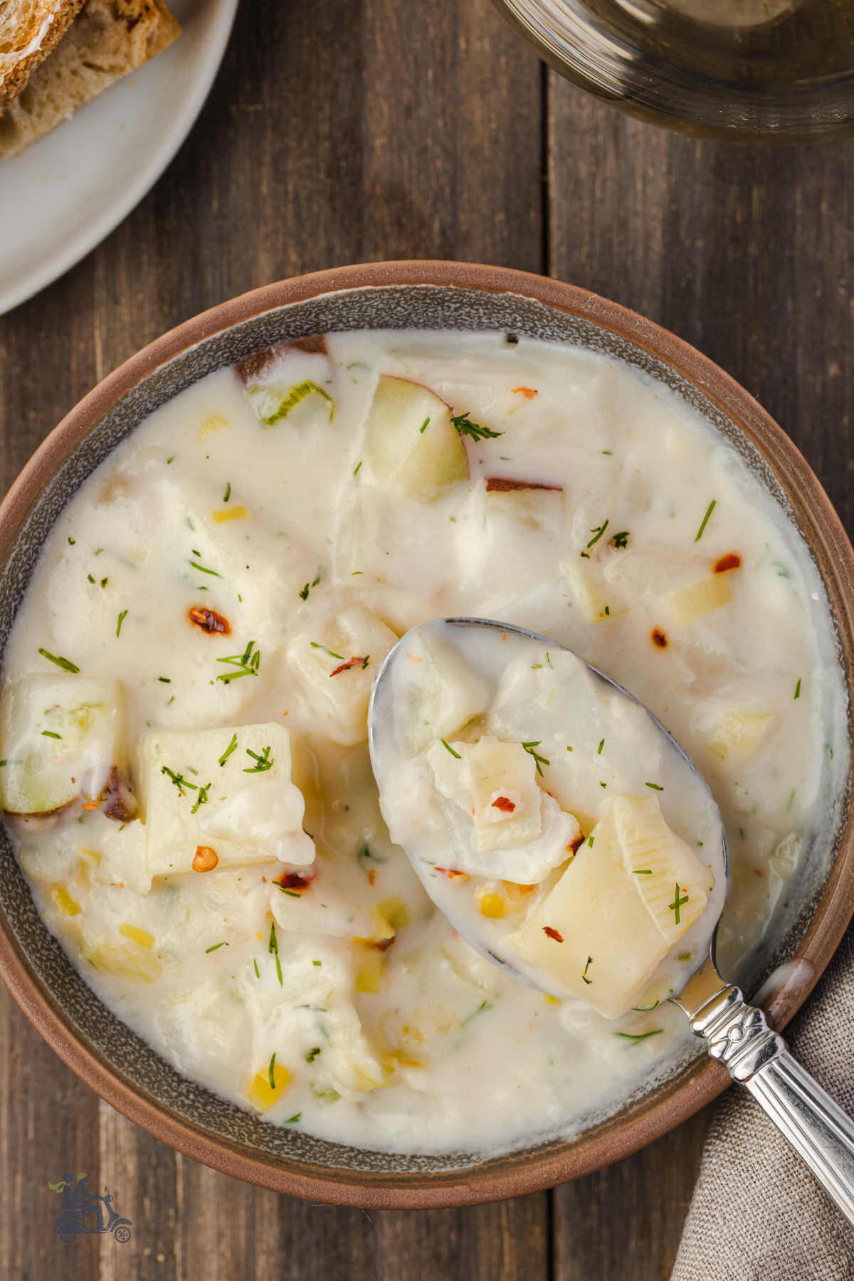 A brown soup bowl filled with fish chowder made with cod or sheepshead. 