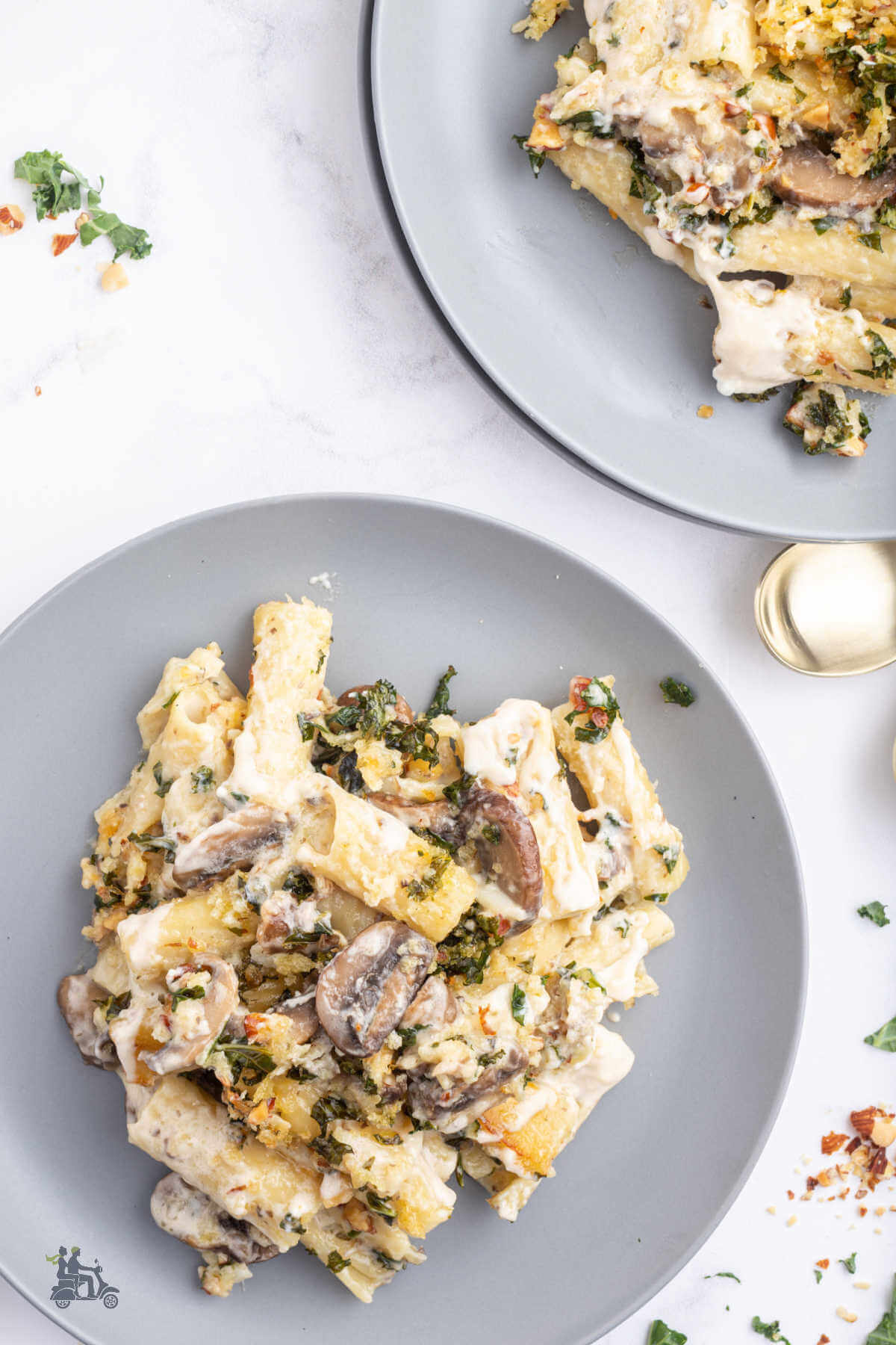 Two gray plates each with a serving of the Mushroom Baked Pasta with Gremolata topping. 