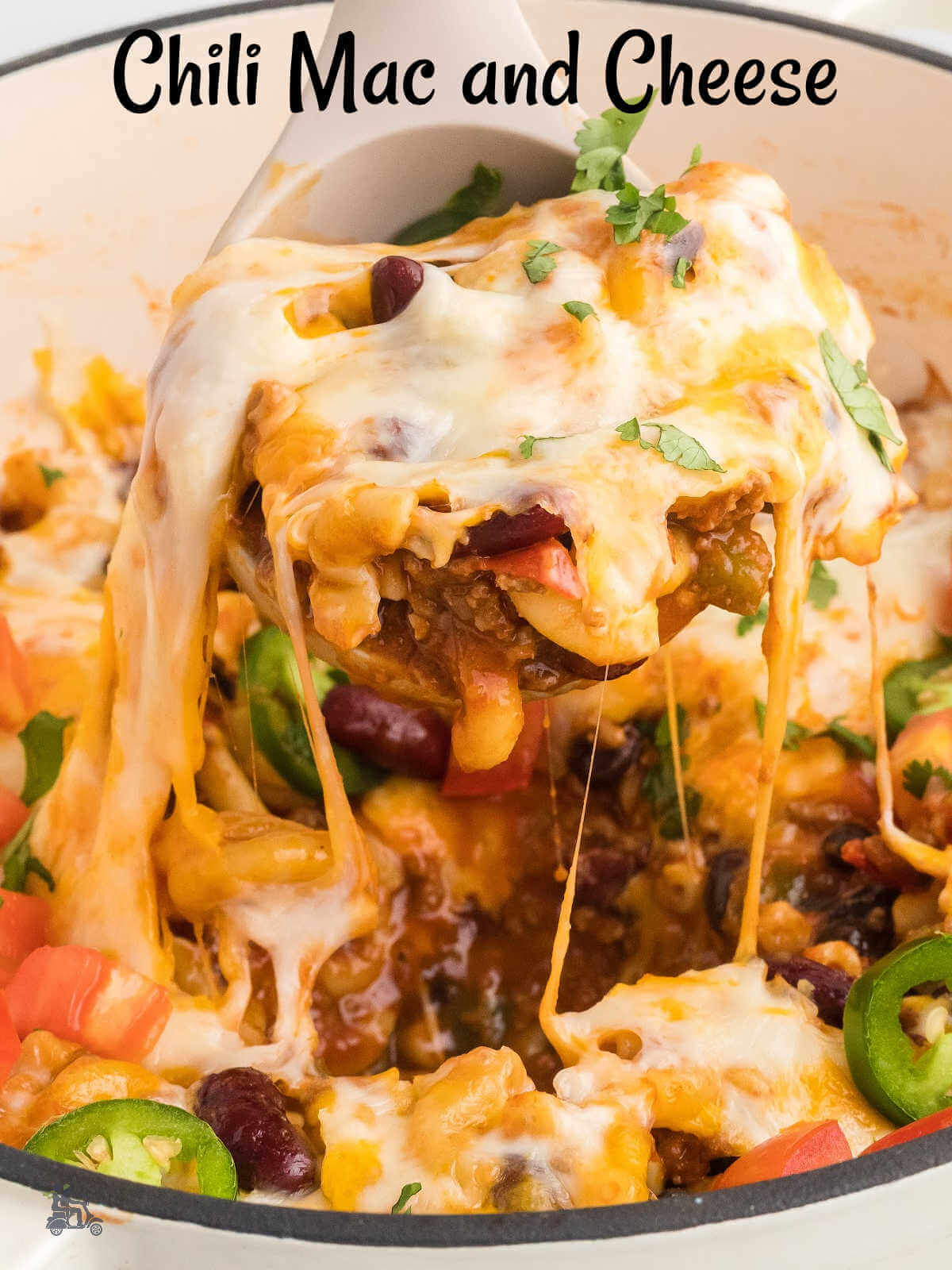 A ladle holding a serving of cheesy ground beef chili macaroni and cheese.