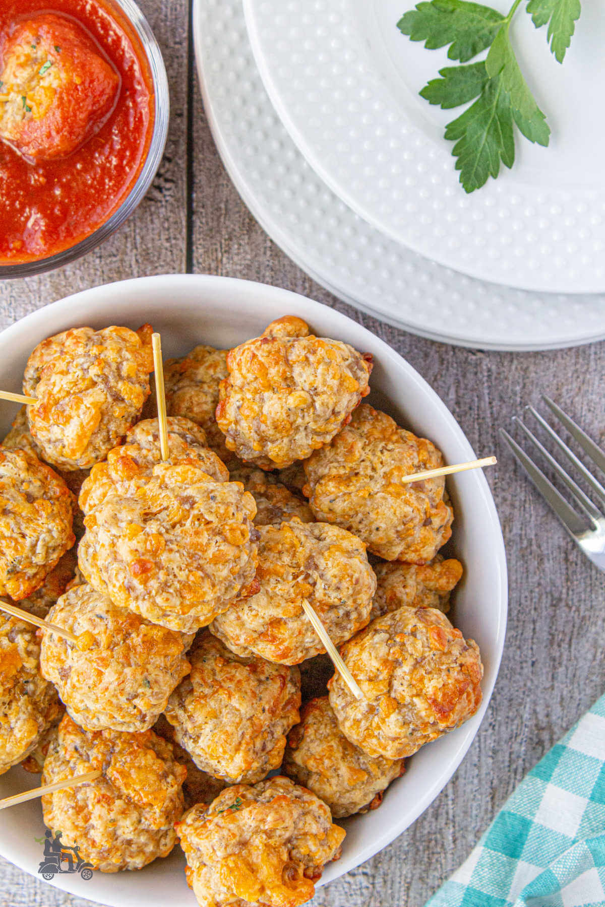 Bisquick Sausage Balls with marinara sauce in the background for dipping. 