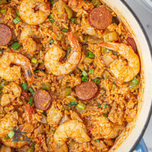 Dutch oven filled with one pot Jambalaya with shrimp, smoked sausage, and rice.