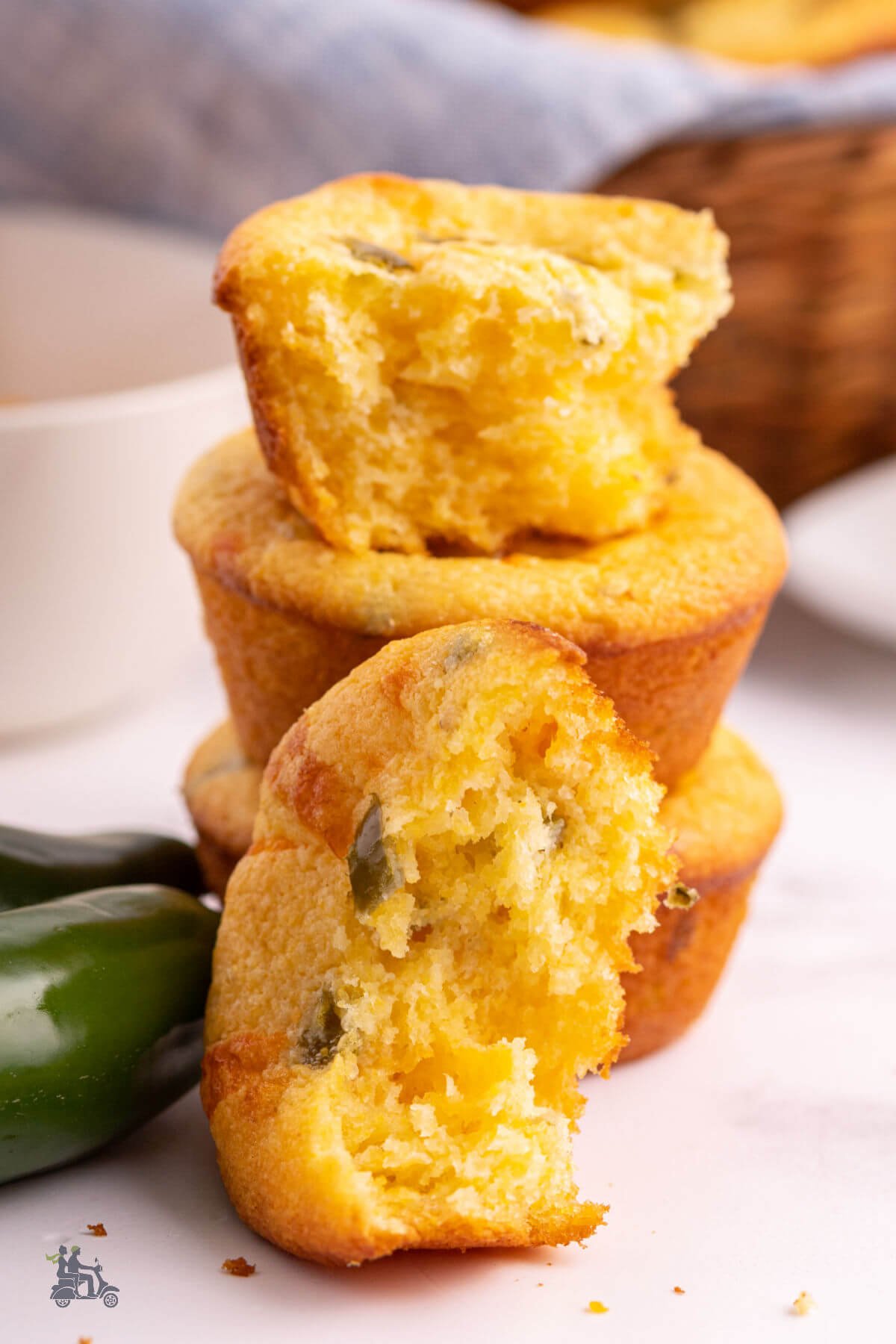 Three Jiffy Jalapeno Cornbread muffin stacked with one split with the moist interior showing. 