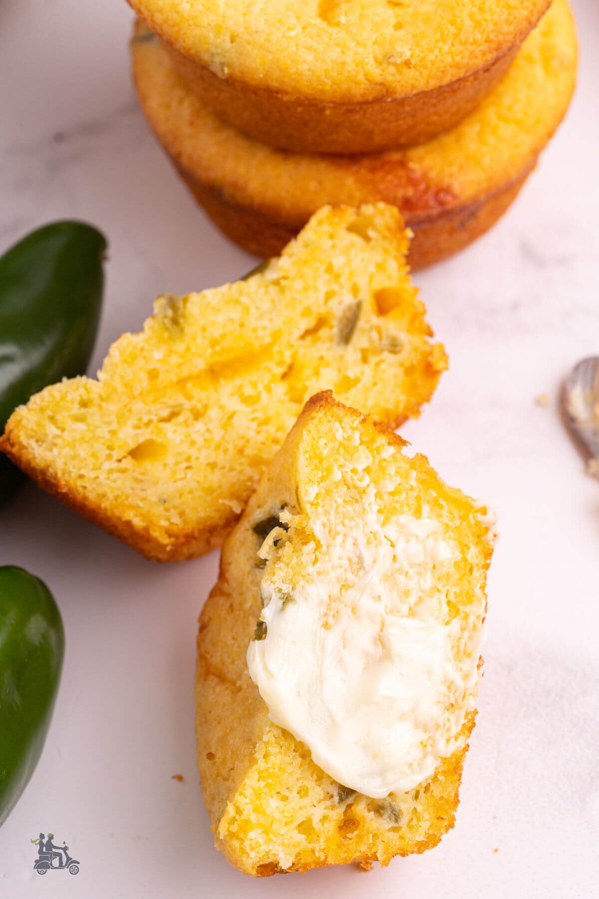 A split corn muffin with cheese and jalapenos slathered with butter. 