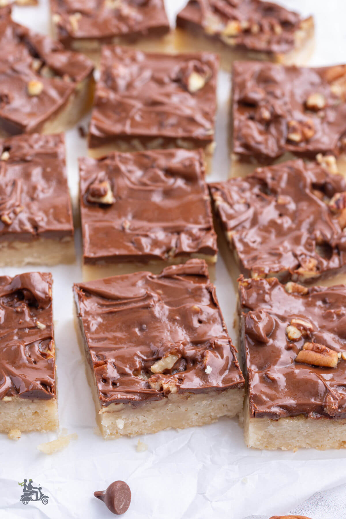 Caramel Pecan Bars sliced and on white parchment paper. 