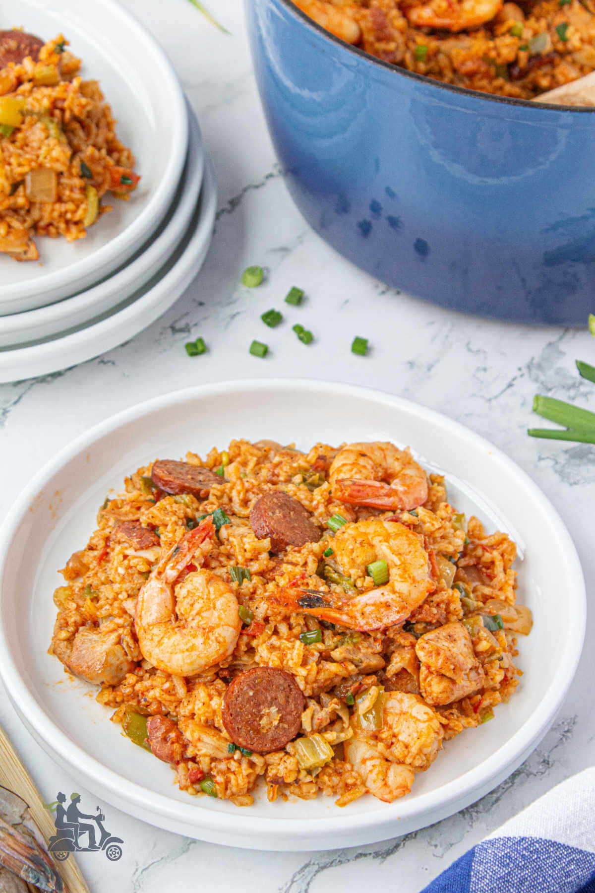 A white bowl filled with a serving of Jambalaya made with rice, shrimp, and smoked sausage. 