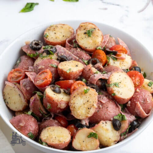 Italian Potato Salad tossed with a zesty vinaigrette and made with antipasto ingredients such as Italian olives, salami, and fresh basil.
