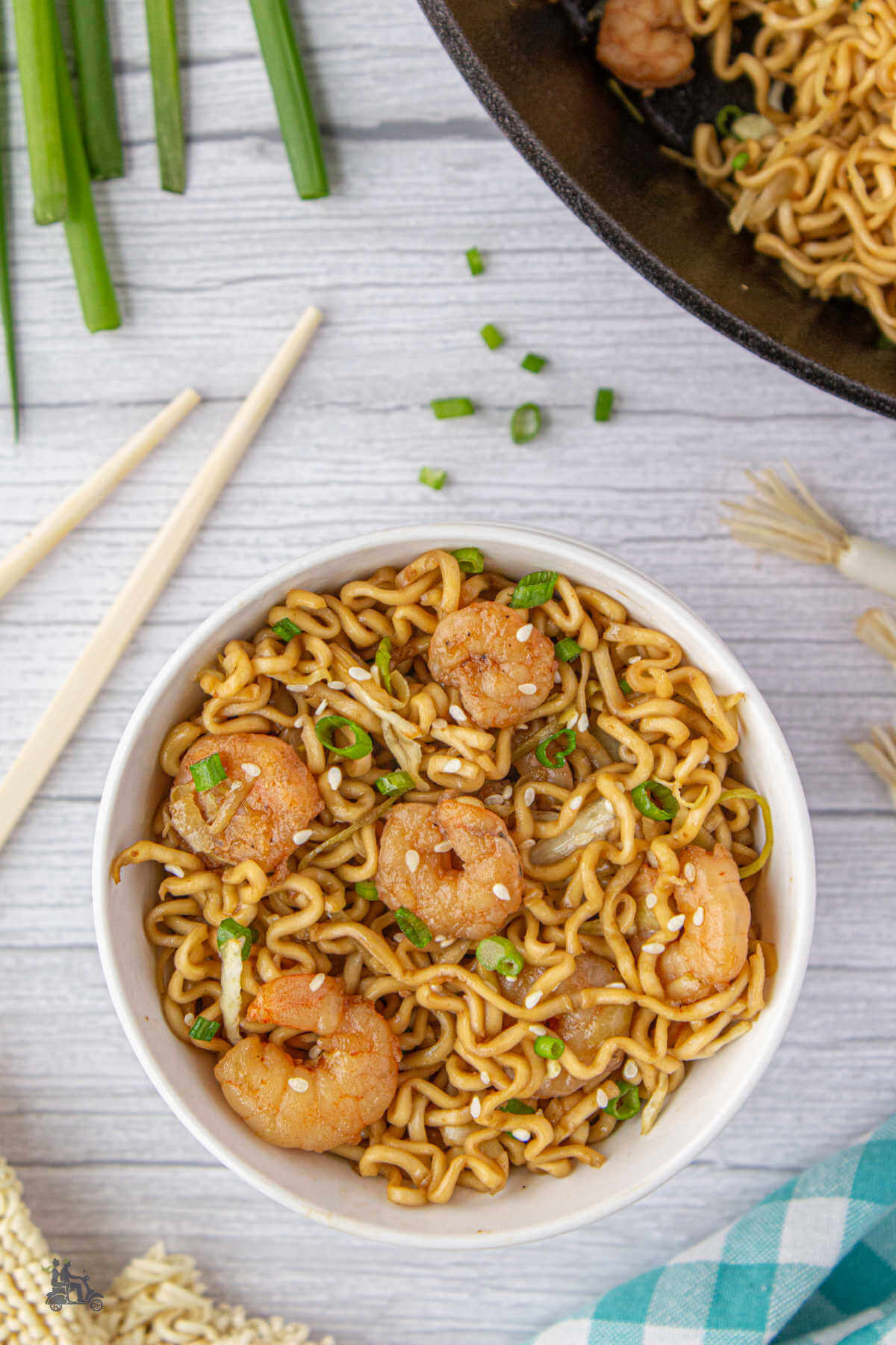 An overhead view of the teriyaki noodles with shrimp recipe in a white bowl. 