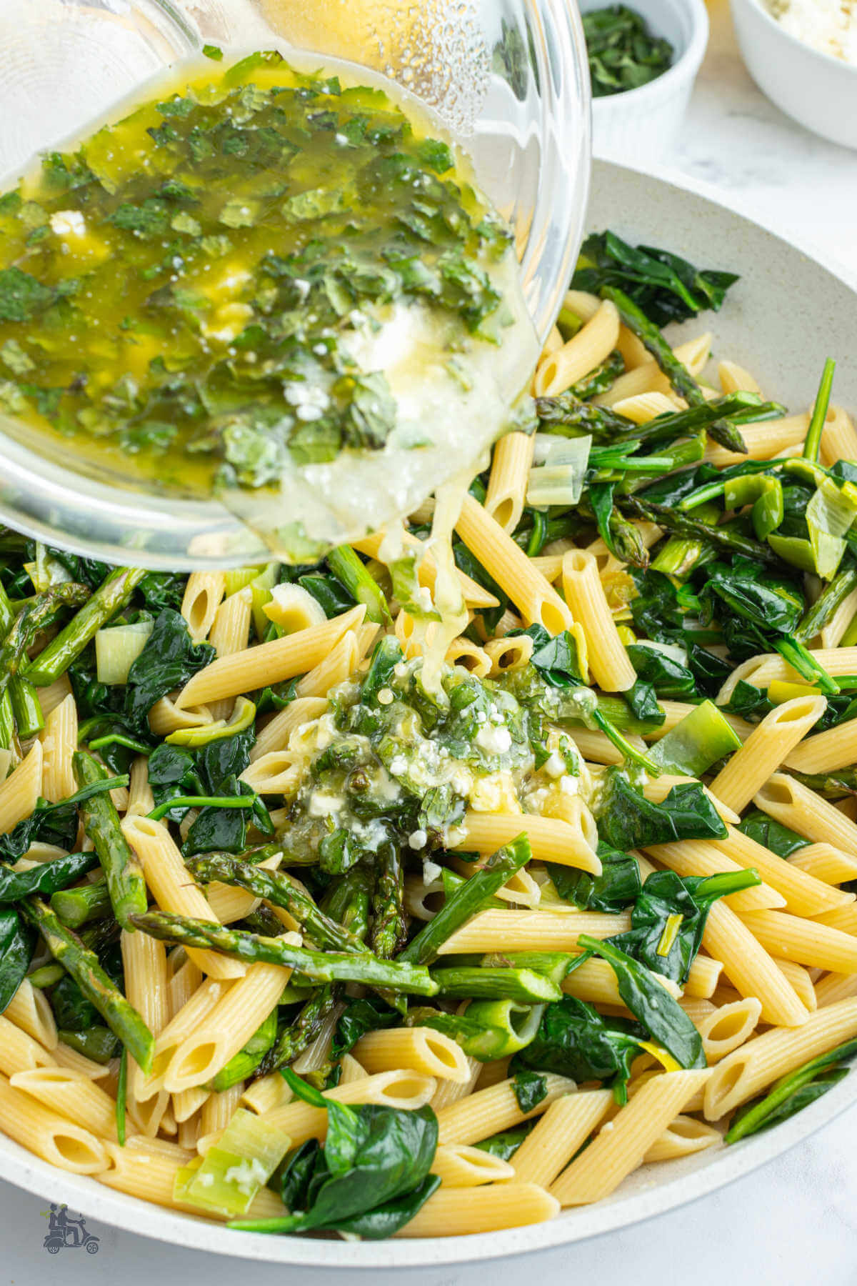 The final step to making the primavera pasta is the pouring of the lemon vinaigrette over the ingredients. 