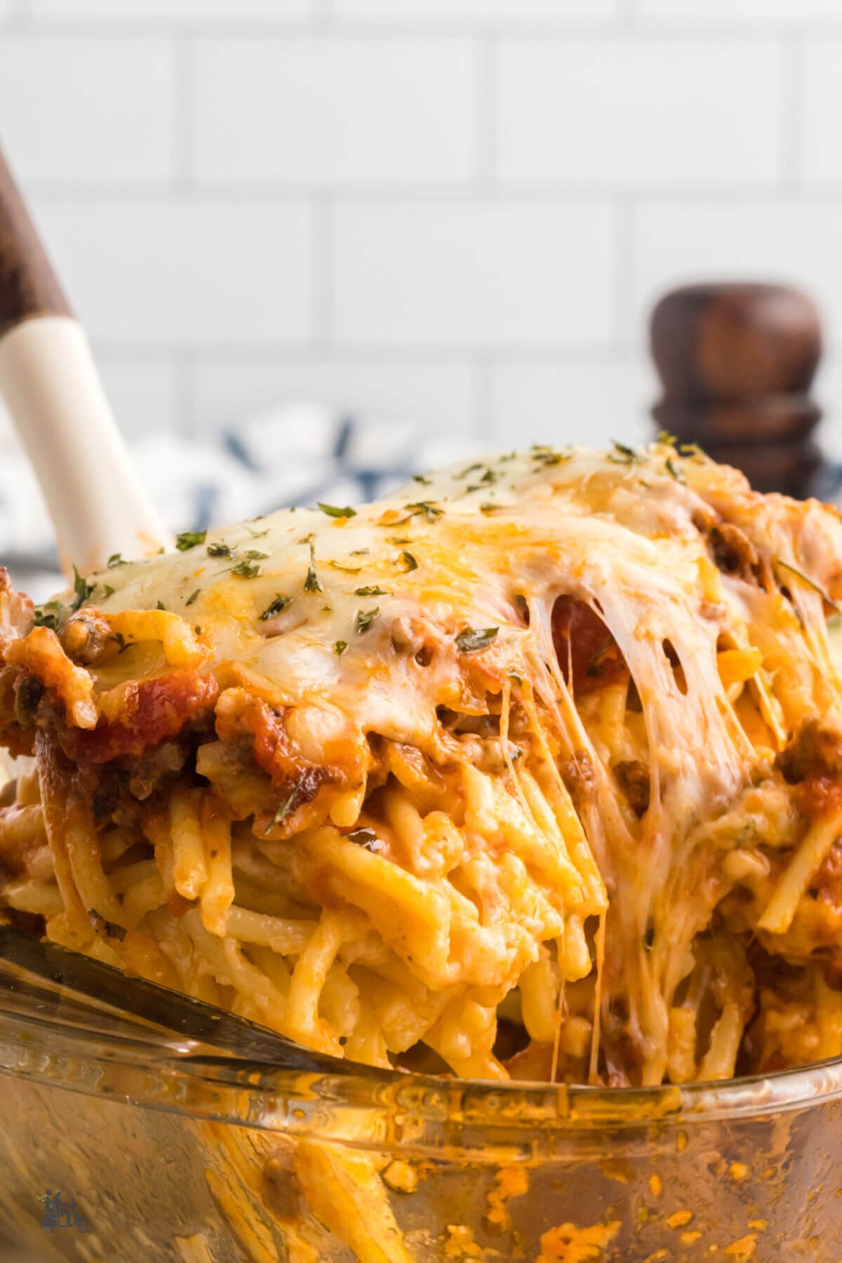 A spatula lifting a serving of cheesy spaghetti Alfredo. 