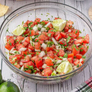 A glass bowl filled with Pico de Gallo a fresh Mexican salsa.