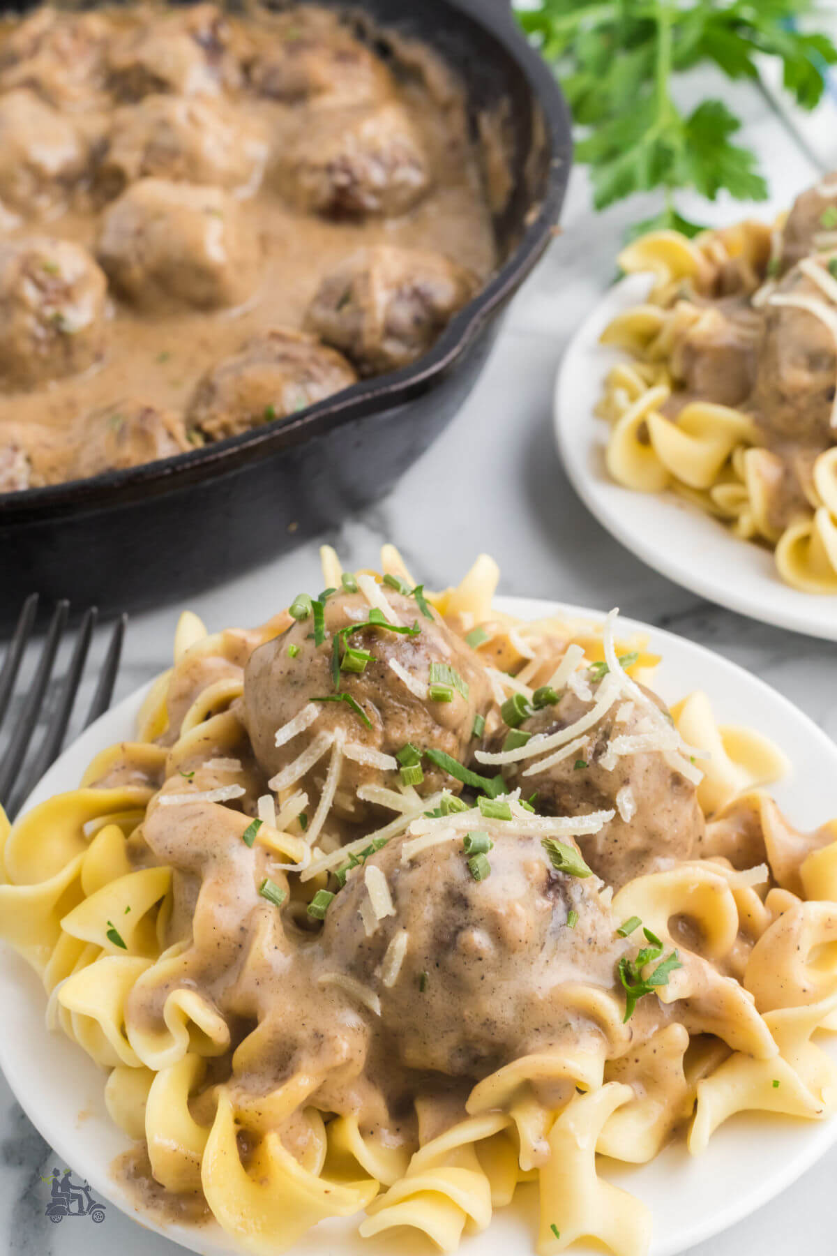 Swedish meatballs covered in sauce on top of egg noodles. 