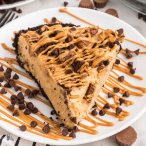 A slice of Chocolate Peanut Butter pie with crushed Reeses cups on top and a chocolate oreo crust.