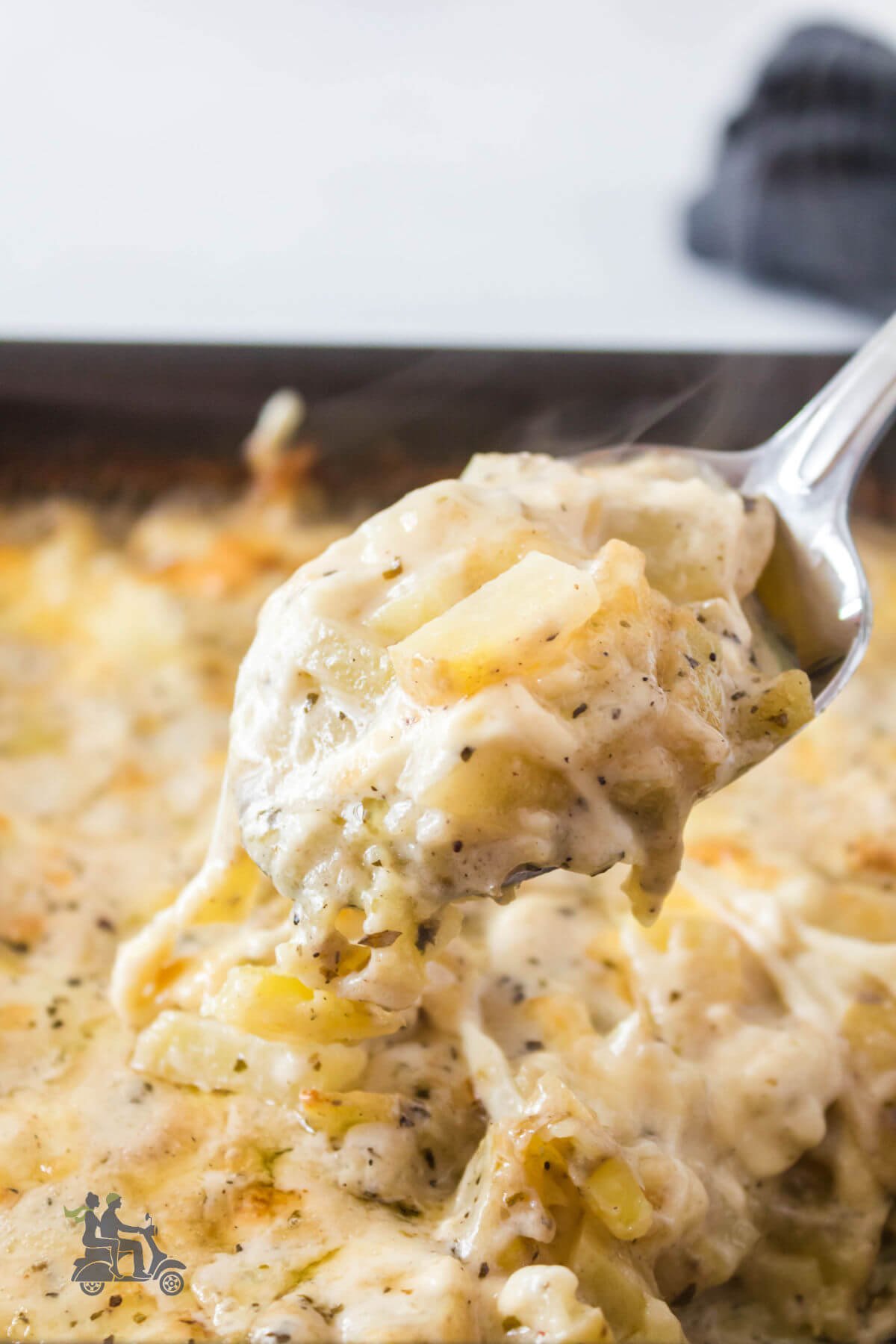 A black casserole dish with creamy diced potatoes au gratin. 