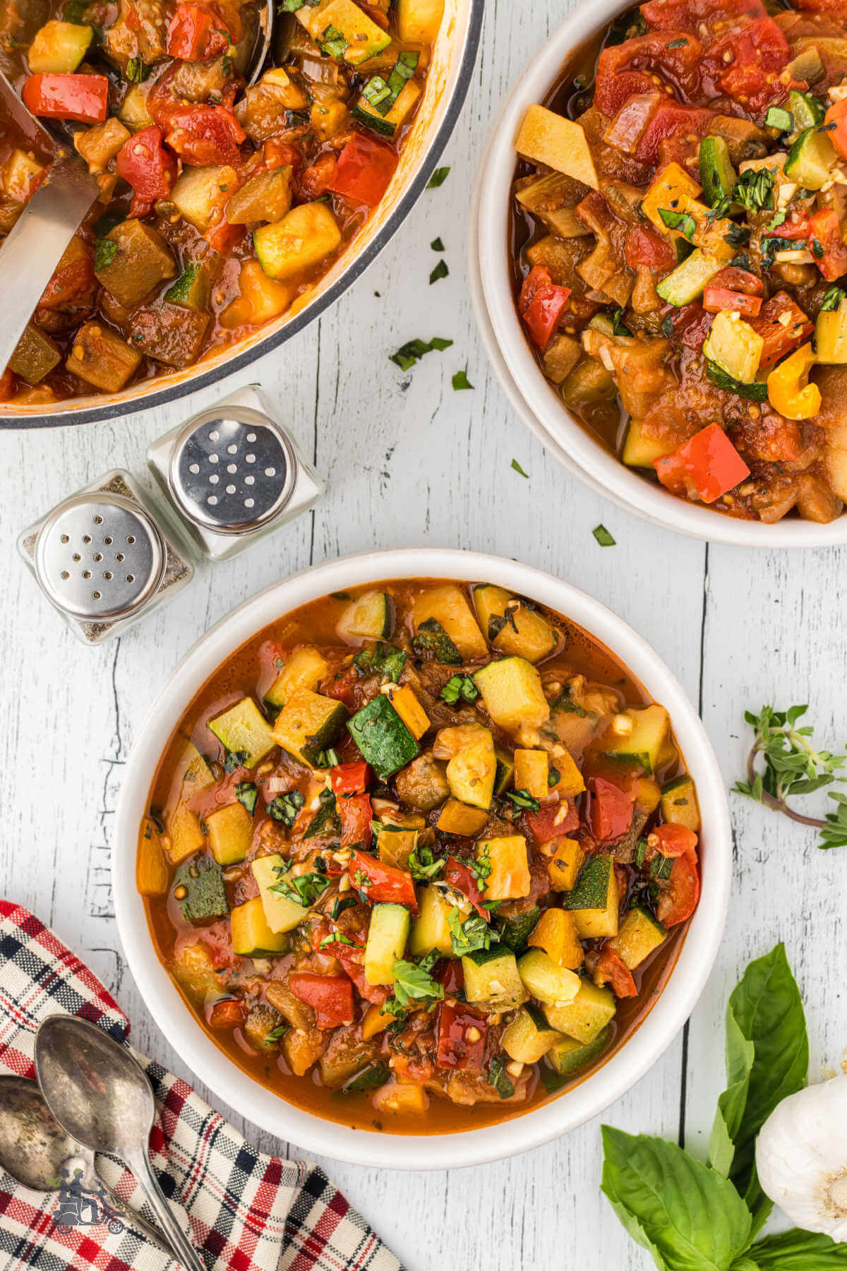 Two bowls with a Dutch oven filled with Giambotta an Italian vegetable stew.