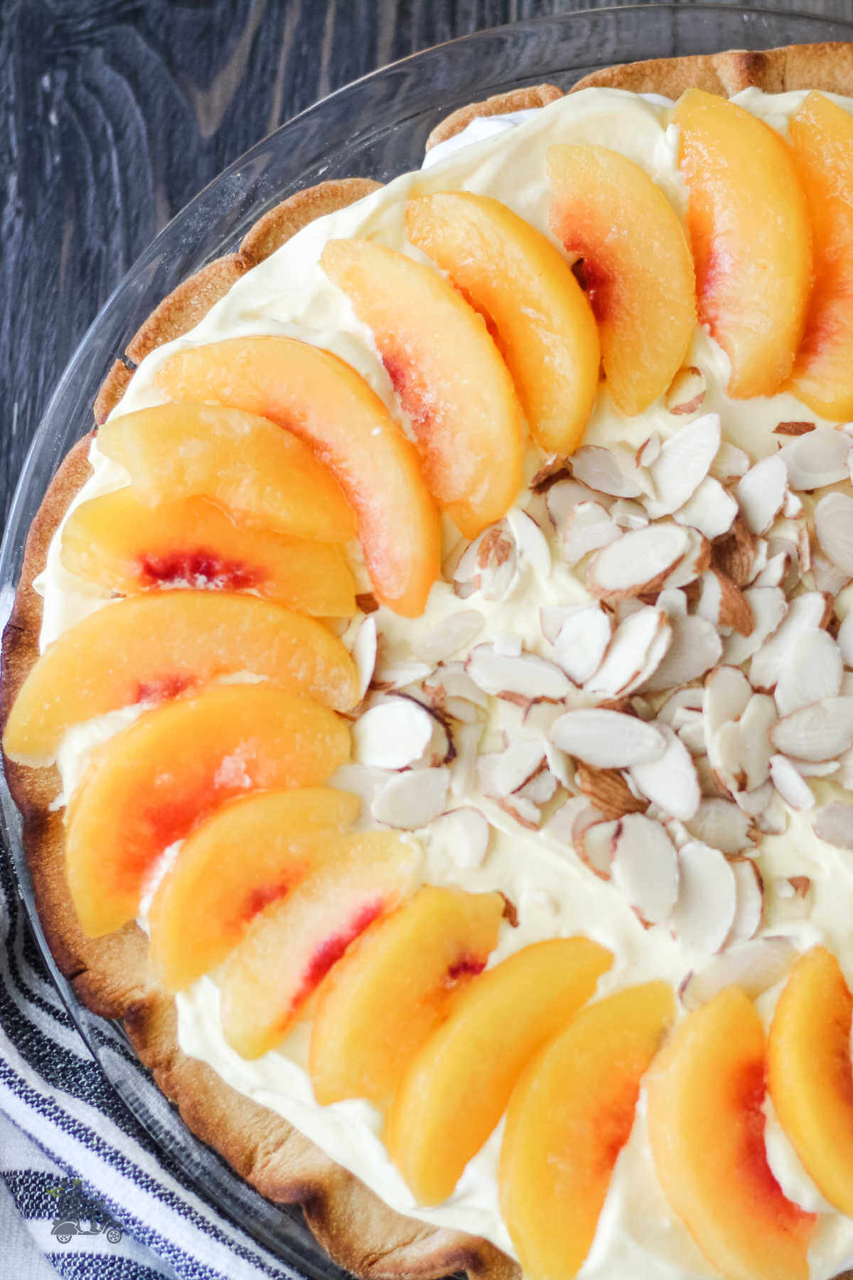 Creamy Peach Pie in a baked pie shell with additional sliced peaches on top. 