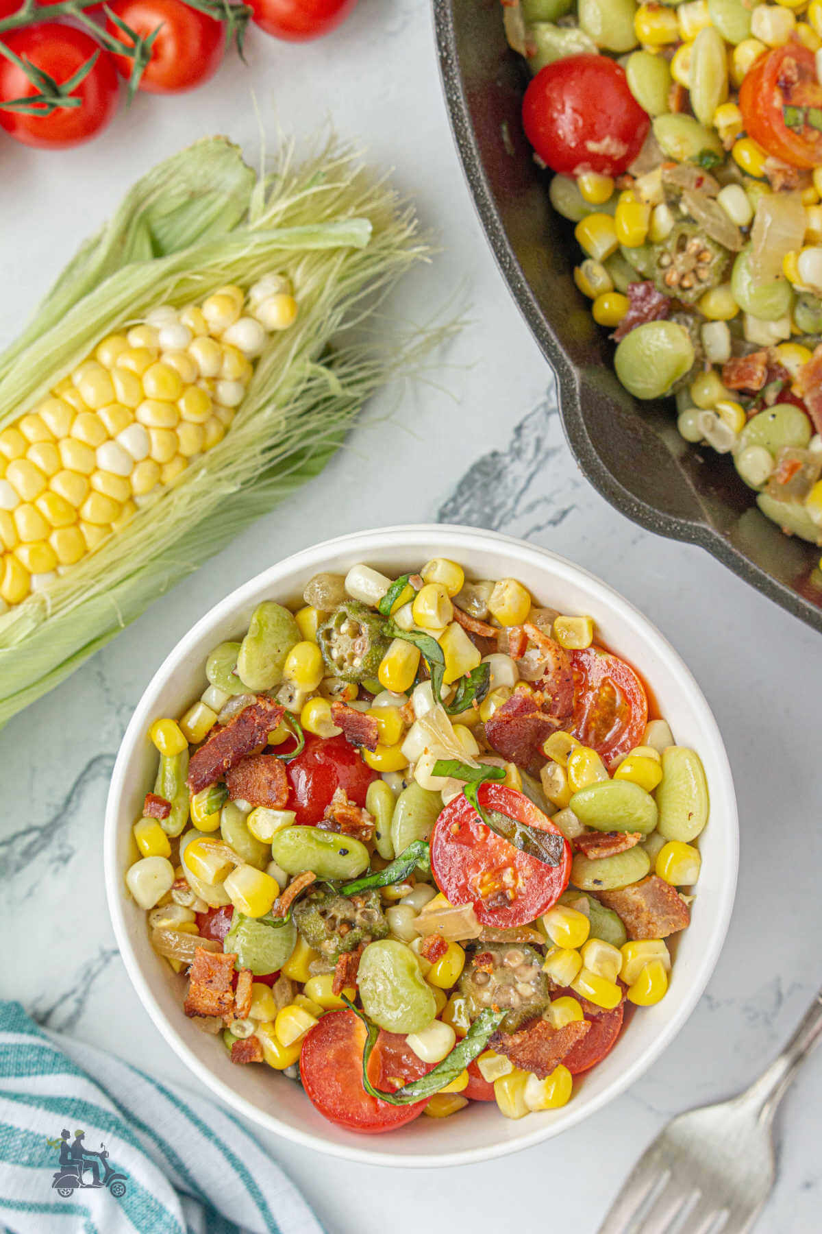 A white bowl filled with a serving of lima bean and corn succotash with bacon. 