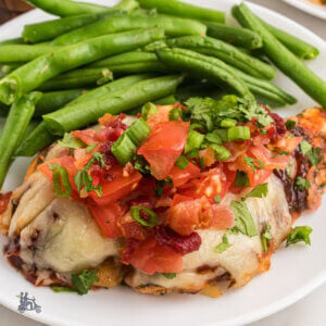 Chicken Monterey a Chili copycat recipe on a white plate with a serving of green beans.