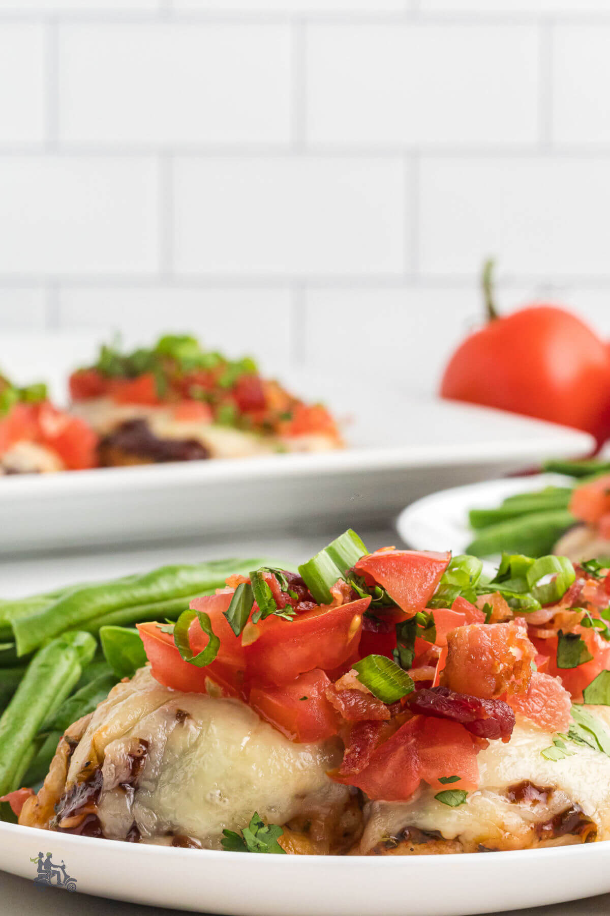 Side view of the Monterey Chicken baking dish in the background and a serving of the chicken dinner in the forefront. 